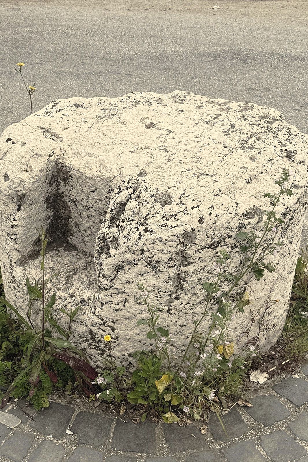 Il cippo romano in pietra, all'imbrunire, all'incrocio accanto alla dimora