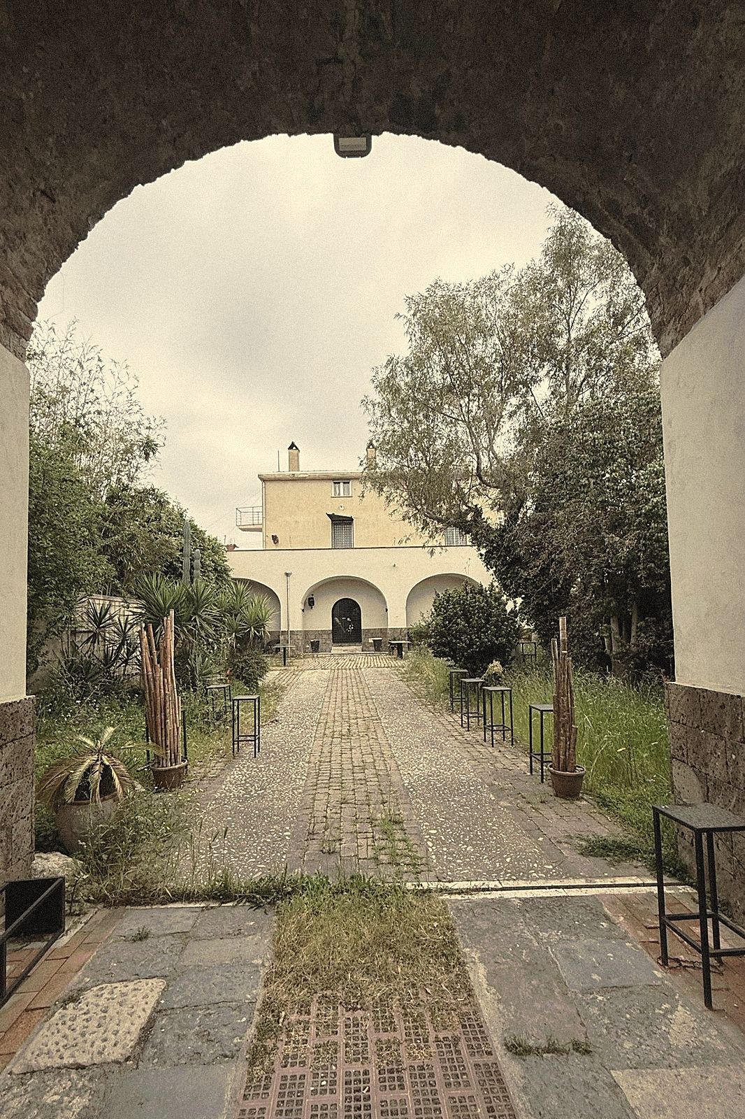 Dall'arco d'ingresso lo sguardo si apre sul cortile interno e sulla casa in fondo